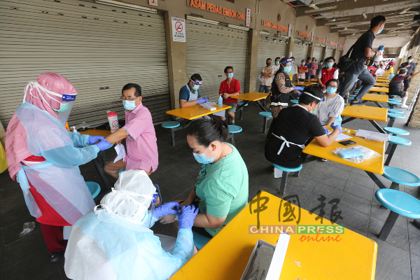 大批商贩集聚批发公市小贩中心以领取肺炎检测报告。