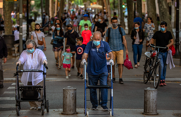 西班牙民众周一在巴塞罗那的一条街道行走散步。（美联社）