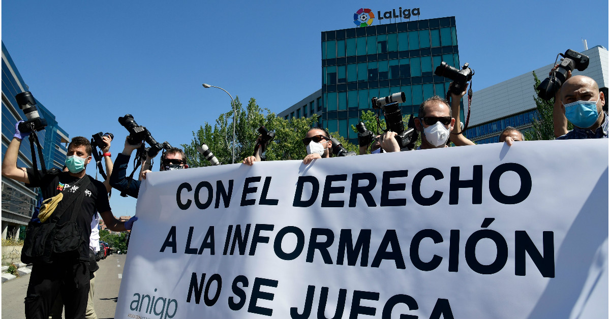 我们也要参与“重启”。西班牙摄影记者在西甲总部外示威，展示 写上“知情权不是游戏”口号的横幅，抗议空场比赛对摄记施加的限制。（法新社）