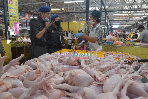 莫哈末艾祖丁（左起）与阿兹法米基向鸡贩了解肉鸡飙涨情况。