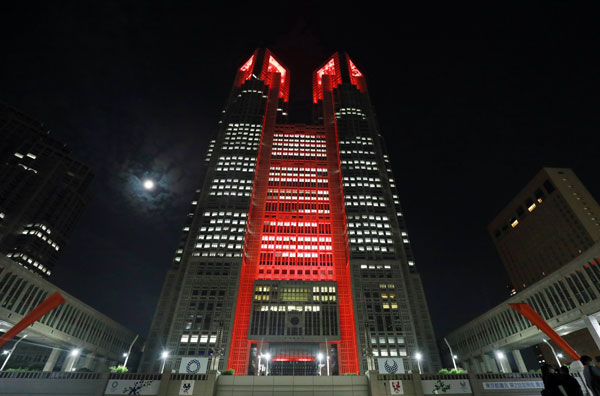 东京都政府大楼和东京湾地标性建筑“彩虹桥”，亮起象征“警戒”的红色，以唤起民众注意。（欧新社）