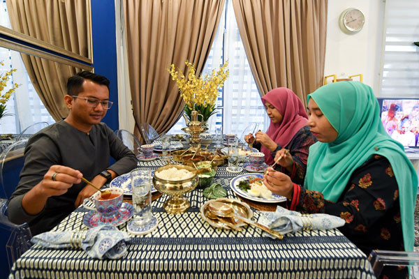阿马莫哈末法依沙（左）与家人日常用餐时，也大量使用铜制餐具。（马新社）