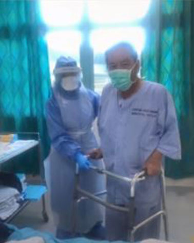 陈文和（右）在病房内，以助行器辅助行动。