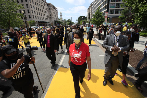 华盛顿特区市长鲍泽（中）走在白宫前道路上，这条路已改名为“黑人的命也是命”广场。（美联社）