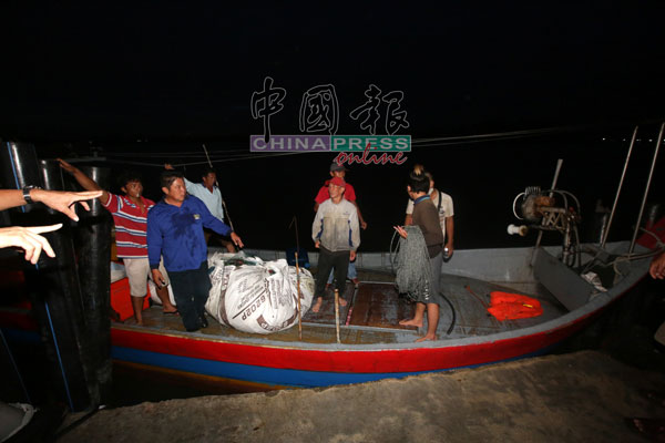 参与搜救的许海强(蓝衣者)带着张宏裕(中)及马永亮，率先抵达码头上岸。