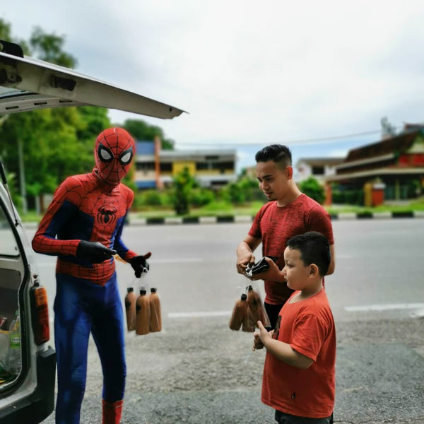 蜘蛛侠在路边售卖瓶装冰拉茶，大人小孩都喜爱。