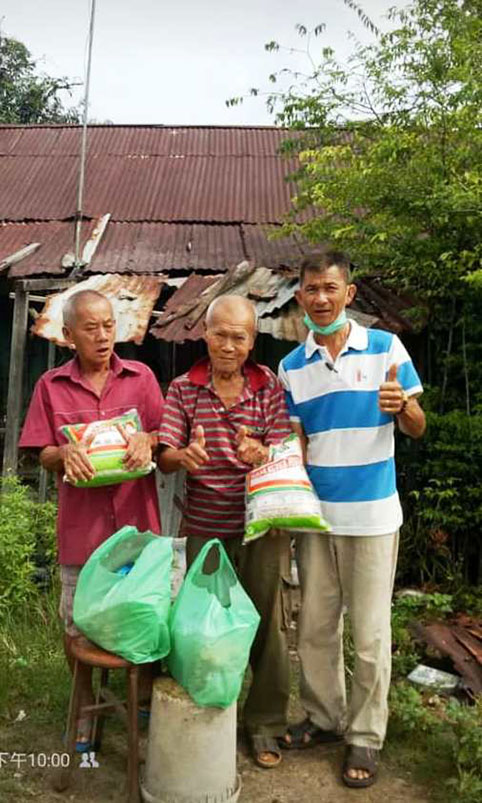 曾贵兴（右起）曾在今年4月间，派发干粮和援助品予李呀和另一孤老。