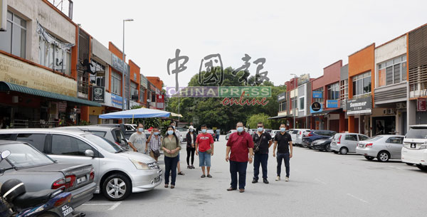 萧开文（前排右）和叶小瑂（前排左）和小贩们巡视早市营业地点。