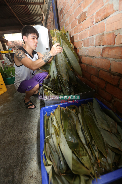 陈桂莲的孩子分工合作将粽叶洗涤干净。