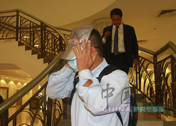 涉嫌受贿的弗兹兰阿都拉迪（前）获保外，以帽子掩盖脸部后离开法庭，后者为代表律师慕纳圭卡比尔。