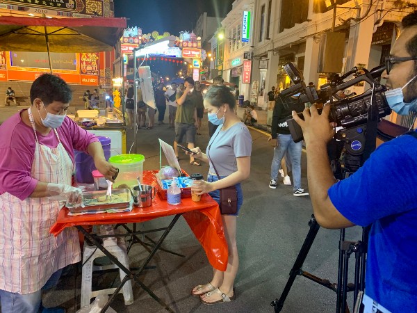 电台媒体采访队伍摄录鸡场街集市的各种特色美食。