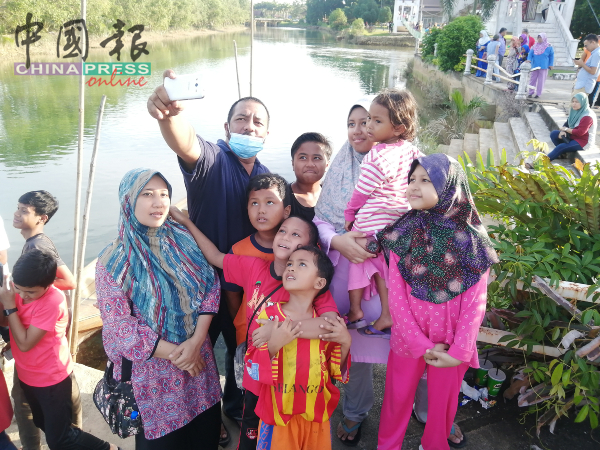 罗斯丹华希（手持手机者）与家人到吉双河自拍。