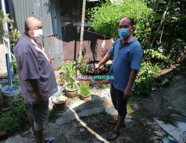 罗子伦（左）向梁证法反映沟渠阻塞，排水不顺，也导致很多蚊子。