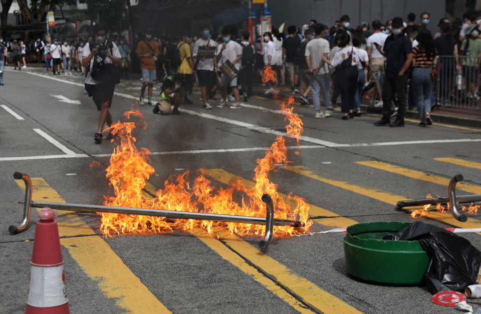 示威者周三（7月1日）在香港铜锣湾燃烧一个路障，企图阻止警方靠近。（欧新社）