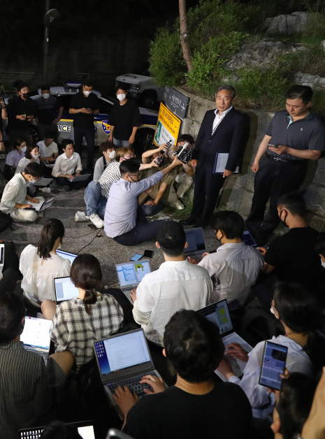 首尔警察局警官崔益秀（右2）周五凌晨在首尔卧龙公园召开新闻简报会，媒体坐在地上采访写稿。（欧新社）