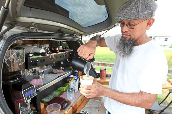莫哈末法兹阿兹米开着一辆改装的休旅车，在住家附近做流动咖啡馆的生意。