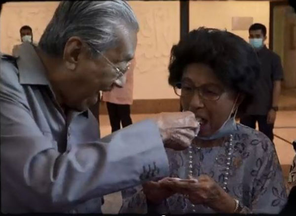 害羞的马哈迪（左）在众人起哄下，鼓起勇气喂食蛋糕给西蒂哈丝玛。