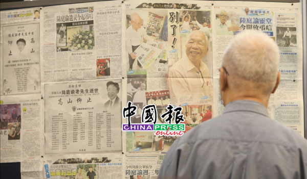 公众站在布告板前看《中国报》刊登的画页，细读陆老生前点滴。