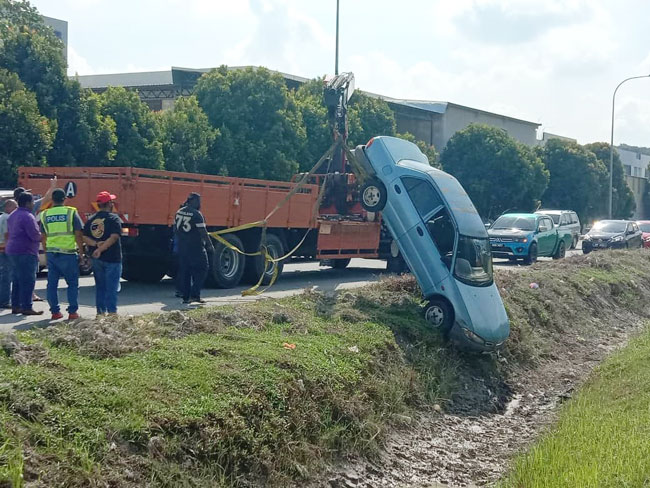 拖车员将肇祸轿车，移出沟渠。