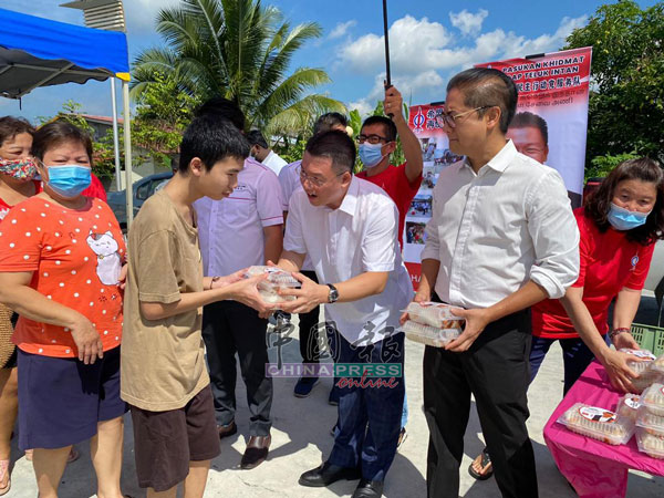 倪可敏（右2）联同州议员添仁奈都（右）赠送免费餐给芭尾新村村民。