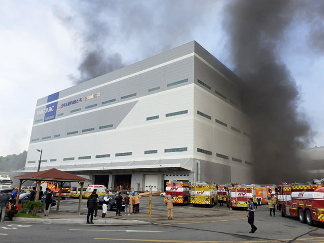 韩国龙仁市一处物流中心周二发生火灾，消防员在现场扑救。（欧新社）