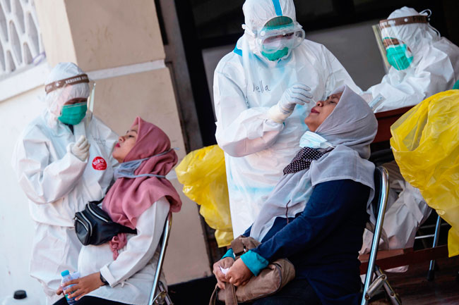 在泗水，医护人员为孕妇进行新冠病毒检测。（法新社）