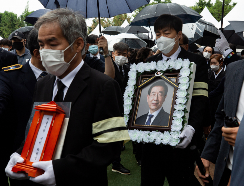 已故前首尔市长朴元淳周一出殡,  图为遗属捧着朴元淳的灵牌和遗像。（欧新社）