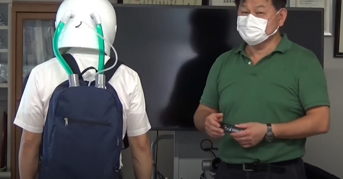 藤井雄作教授（右）在记者会上展示头盔口罩，强调这仅是设计原型。