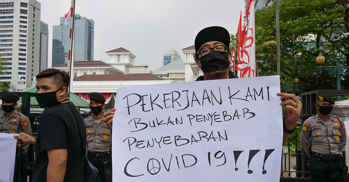 印尼音乐家周三在耶加达市政厅外示威，手持写上“我们的职业不是新冠肺炎传播源”的牌子，要求政府允许咖啡馆重开。（法新社）