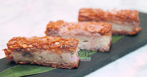 槟榔芋丝饼上层和下层是煎得焦香脆口的手切芋头丝，中间则是以猪肉、虾肉和鱼肉混合而成，有嚼劲而不韧的肉饼。