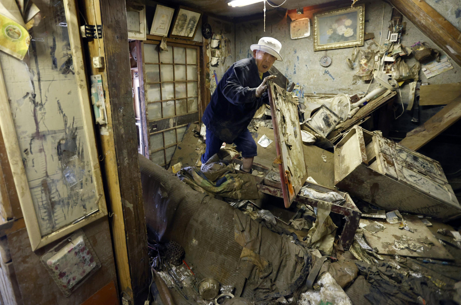 熊本县人吉市一名居民，在住家收拾被水淹过的物品。（美联社）