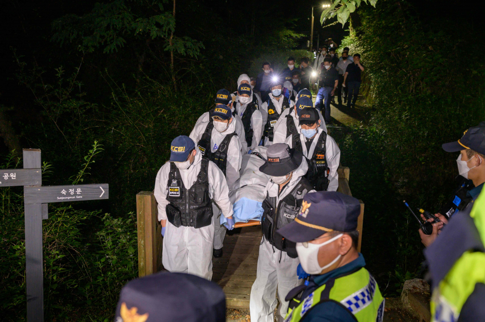 韩国警方鉴证科学组人员，周五凌晨在首尔成均馆大学后门卧龙公园附近寻获朴元淳的遗体。（法新社）