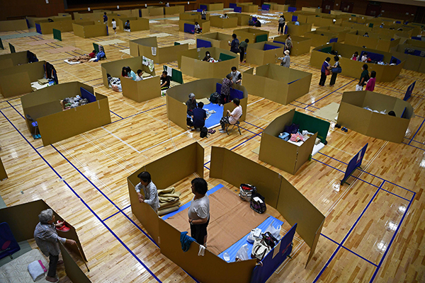 熊本县八代市的灾民，在体育馆避难中心间隔特定距离休息。（法新社）