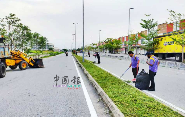 市议会员工分工合作清理大道旁的野草。