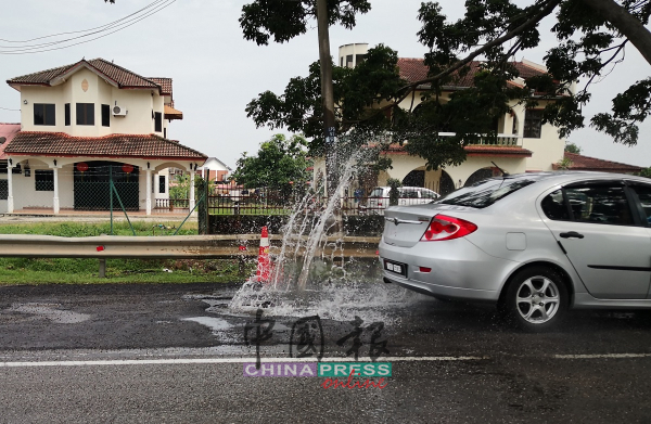 车辆撞上路洞时，水花四溅。