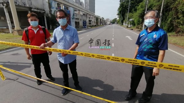 警方在敦阿里路口处围起黄线，以让路给维修工作。左起是朱智威、刘志良及陈劲源。