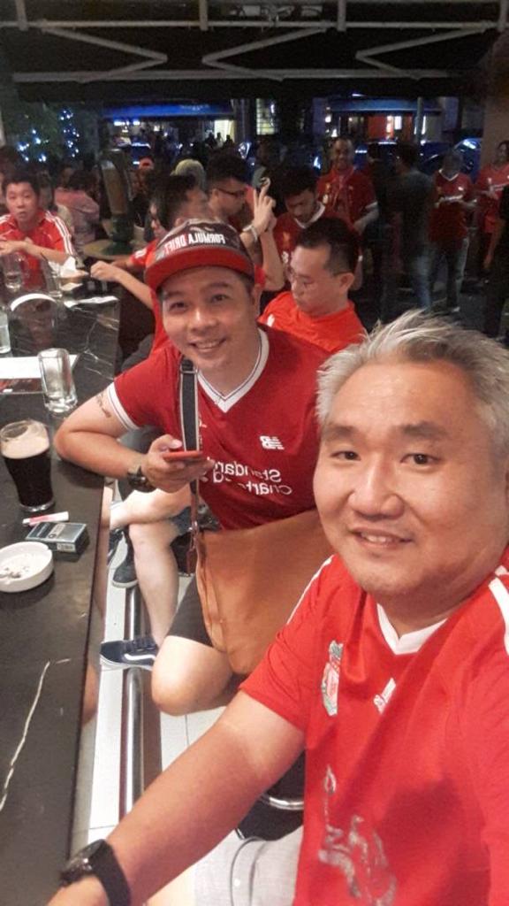 梁永佳（前）与詹姆斯．陈结伴出席吉隆坡利物浦球迷会的看球派对，与志同道合者远距离为红军打气。（梁永佳提供）
