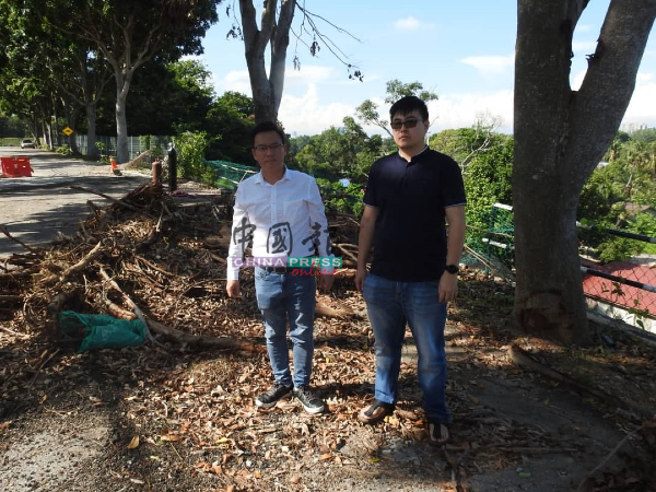 蔡求伟（左）巡视受土崩影响的路段，并促请发展商尽快完成维修工程，右为李茂畅。