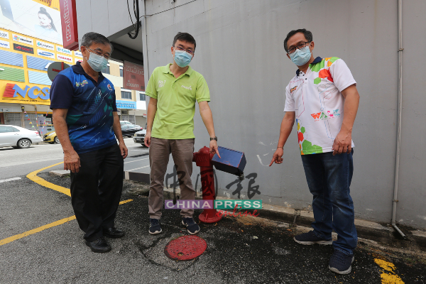 陈为廉（左2）在刘志良（右）及陈劲源陪同下，向媒体指经常遭流浪汉公开小解的消防栓。