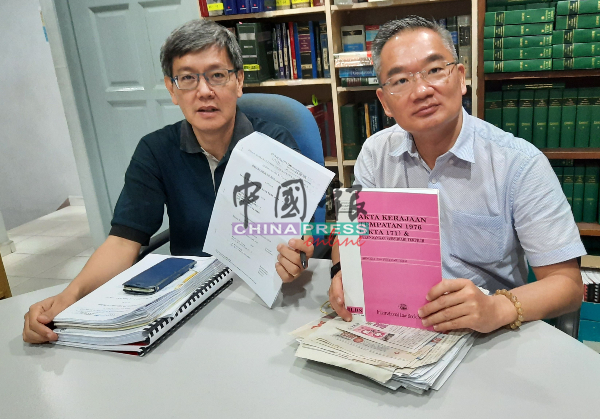 邱培栋（右）与黄光平律师展示市议会涨产业税案的结果。
