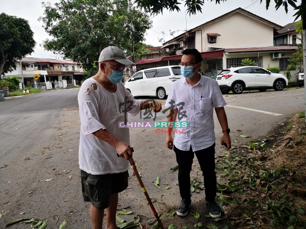 陈文见（左）向蔡求伟投诉，压在屋顶上的树木至今没有清理，令他无法进行维修工作。