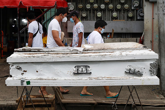 马尼拉市区摆放着一个空棺材，警惕人们待在家，没事别出门。（美联社）