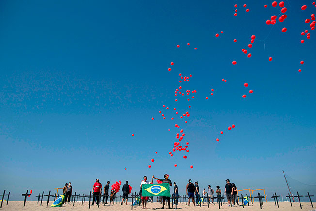 民众周六在科帕卡巴纳海滩，将1000颗红气球放飞，悼念新冠肺炎死者。（法新社）