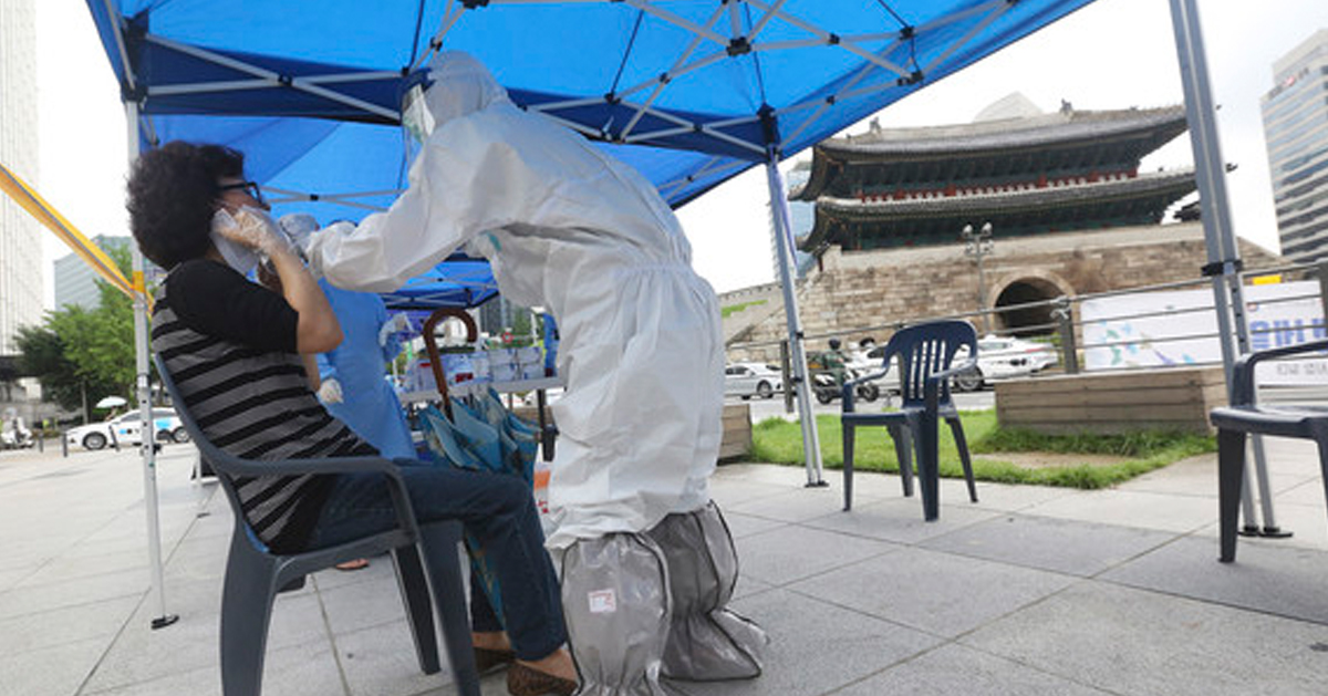 韩国防疫人员在首尔南大门设置临时诊疗所，为商贩提供筛检服务。