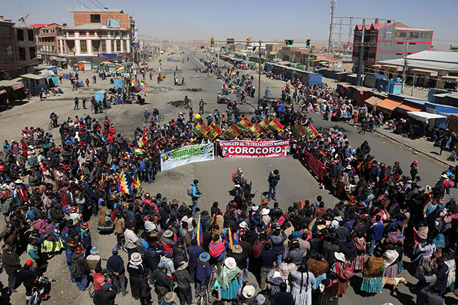 前总统莫拉莱斯的支持者，周三在拉巴斯通往埃尔阿托的高速公路设置路障并示威，抗议选举委员会两度延后总统大选。（法新社）
