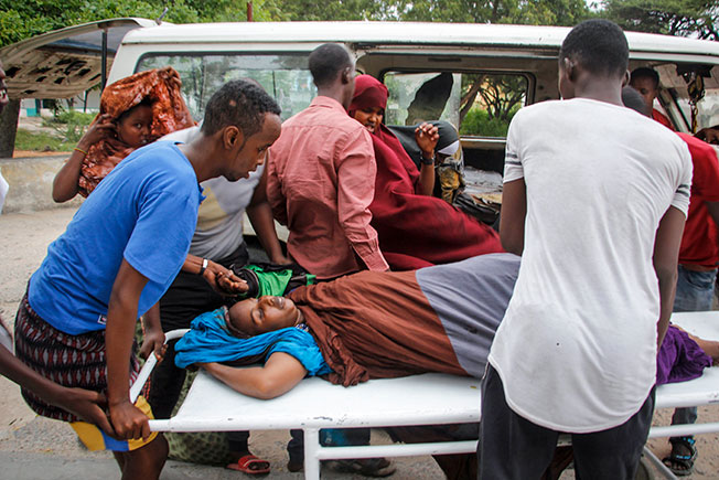 医护人员和民众协助把伤者抬出救护车，准备送院治疗。（美联社）