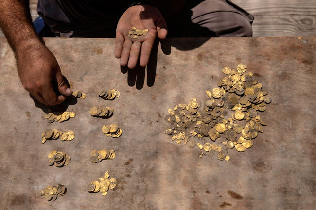 考古志工挖到425枚千年金币。（法新社）