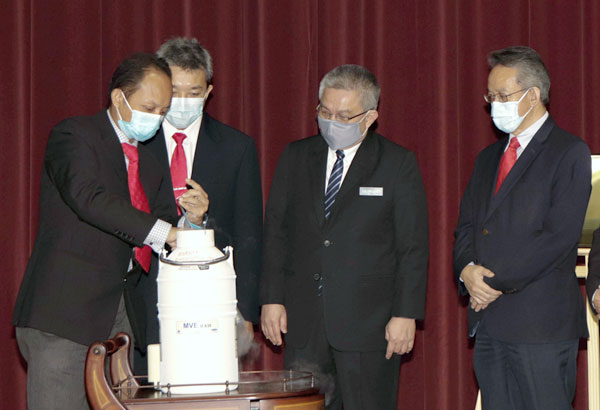 阿汉峇峇（右2）亲眼见证莫哈末韩迪（左）示范，将卵巢组织冷冻保存的过程。（马新社）