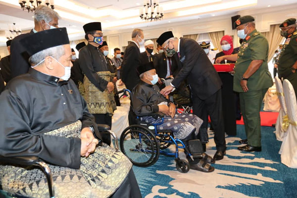 依斯迈沙比里（右2）移交马来西亚服务勋章给一名坐轮椅的退伍军人。