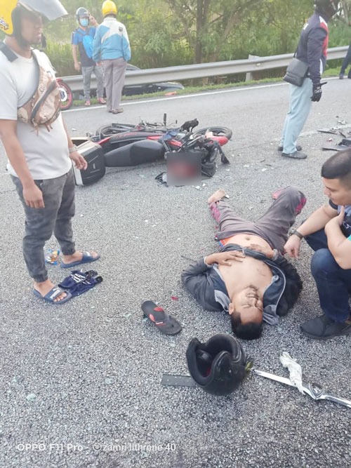 其中一名伤者躺在路面上，等待救援。